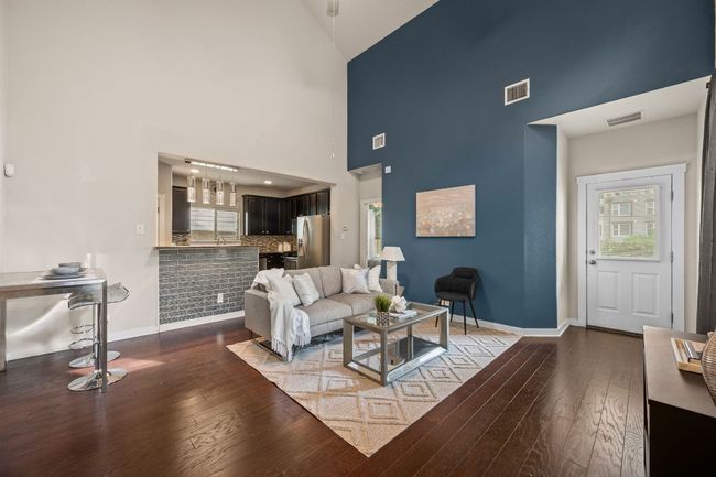 Living room with high vaulted ceiling, healthy amount of natural light, wood-type flooring, and baseboards | Image 5
