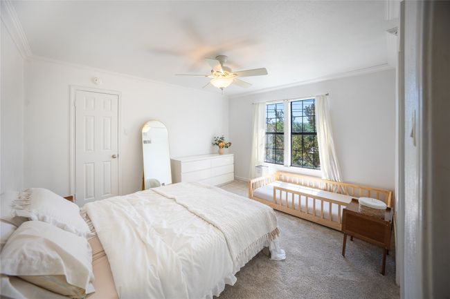 Bedroom featuring light colored carpet, ceiling fan, and crown molding | Image 14