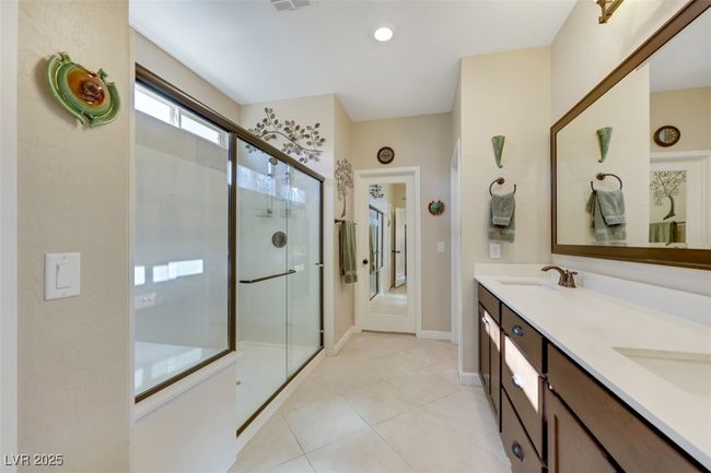 Bathroom featuring a stall shower, tile patterned floors, a sink, baseboards, and double vanity | Image 27