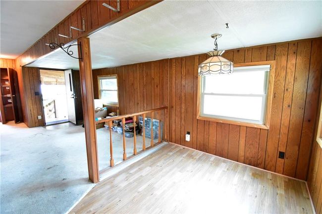 Unfurnished dining area with wooden walls and light hardwood / wood-style flooring | Image 24