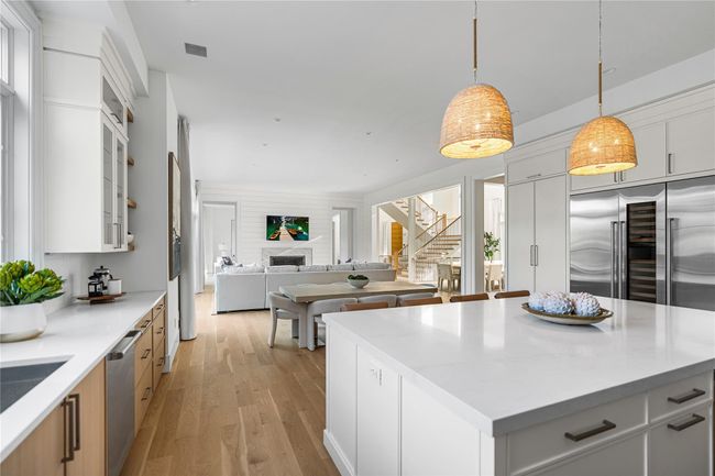 Kitchen featuring appliances with stainless steel finishes, open floor plan, light wood-type flooring, and white cabinets | Image 21