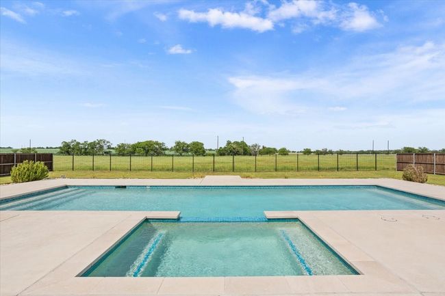 View of pool featuring a pool with connected hot tub | Image 37