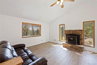 The spacious living room welcomes you with vaulted ceilings, a cozy fireplace, and plenty of natural light | Image 3