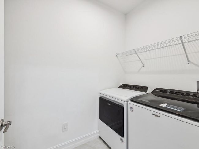 Laundry room featuring light tile patterned floors and washer and clothes dryer | Image 20