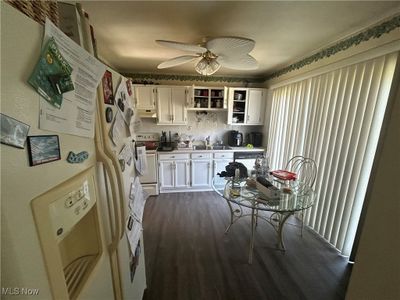 Kitchen featuring ceiling fan, dark hardwood / wood-style floors, white appliances, and white cabinetry | Image 3