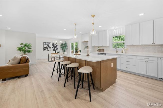 Kitchen with a center island, light wood finished floors, backsplash, white cabinets, and recessed lighting | Image 15
