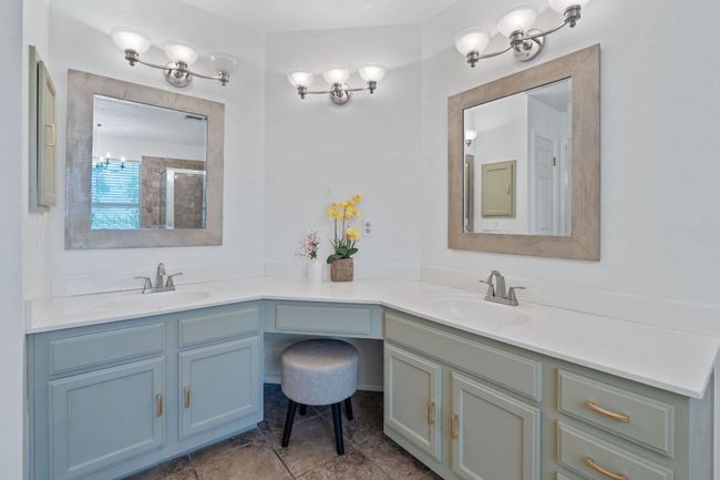 Bathroom with double vanity, tile patterned floors, and a shower | Image 21