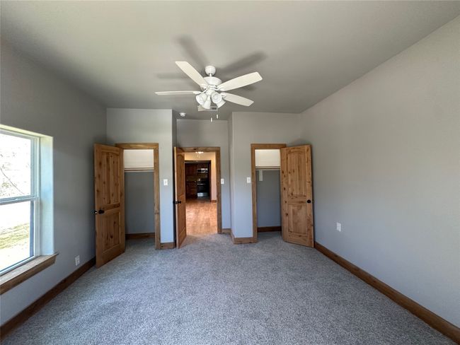 Unfurnished bedroom with carpet floors, baseboards, and ceiling fan | Image 9