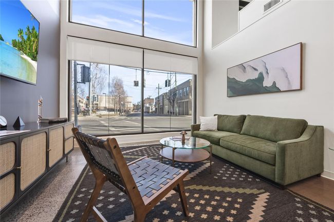 Living area with visible vents, speckled floor, and a towering ceiling | Image 6