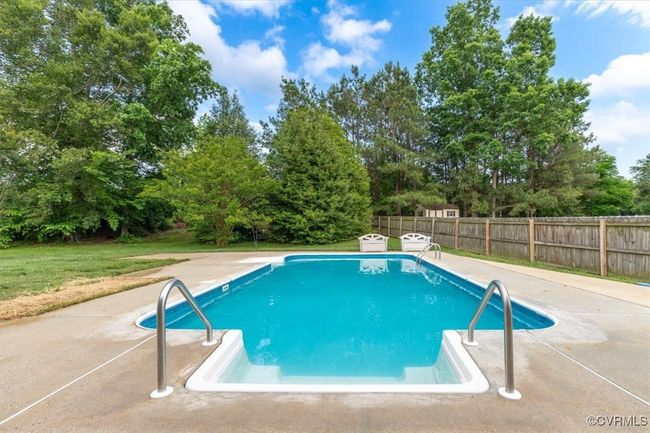 View of swimming pool with a patio area and view of wooded area | Image 47