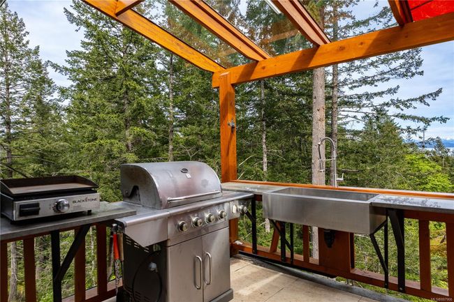 Off the kitchen is the outdoor kitchen with counter and large stainless farm sink | Image 37