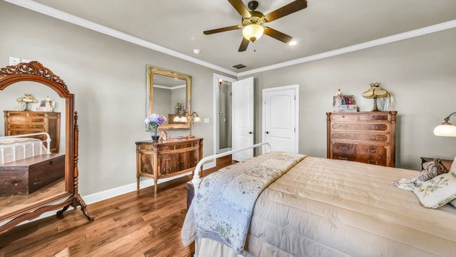 Bedroom with wood finished floors, ornamental molding, and ceiling fan | Image 7