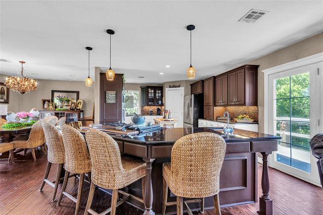 Dining room with healthy amount of natural light, dark wood finished floors, a chandelier, and recessed lighting | Image 8