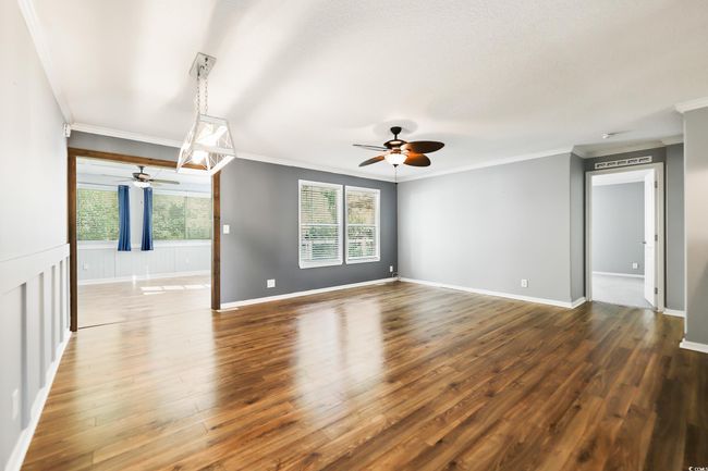 Spare room with a ceiling fan, ornamental molding, dark wood-style floors, and baseboards | Image 13
