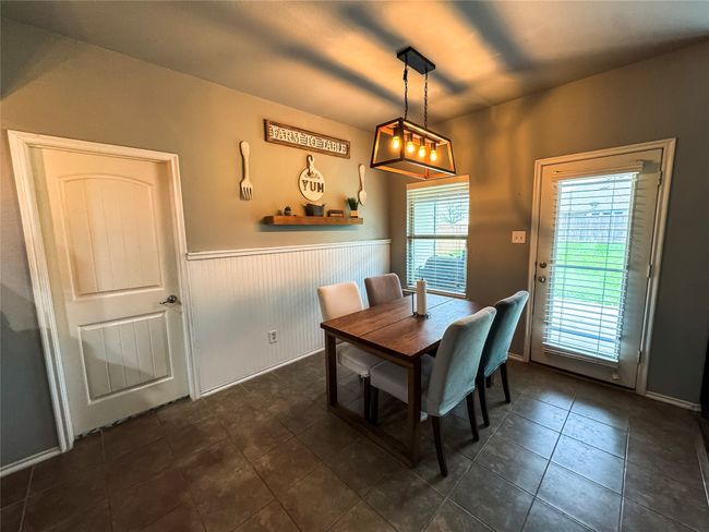 Dining space with dark tile patterned floors and wainscoting | Image 10