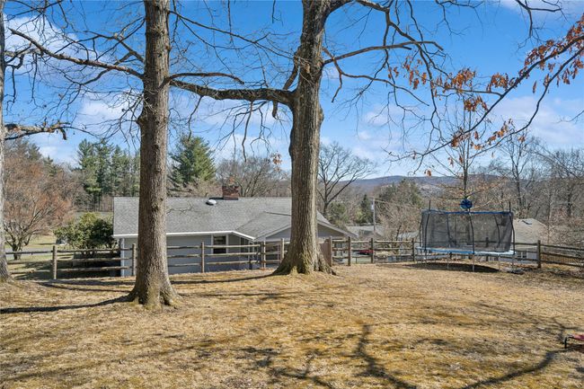 View of yard featuring a trampoline and fence | Image 8