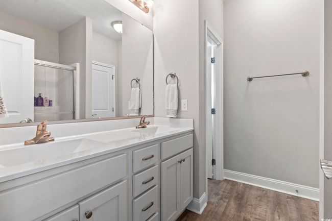 Bathroom with baseboards, a sink, wood finished floors, and a shower stall | Image 22