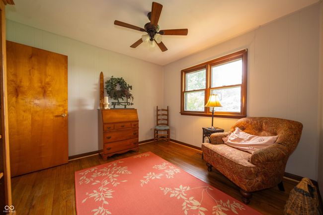 living area featuring hardwood / wood-style flooring, a ceiling fan, and baseboards | Image 11