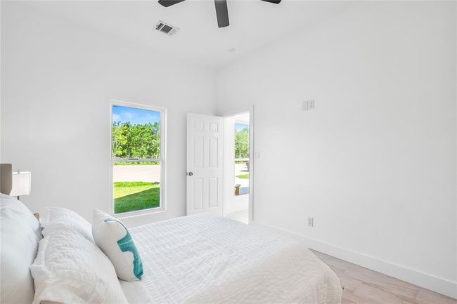Spacious primary bedroom with abundant natural light and serene views. | Image 17