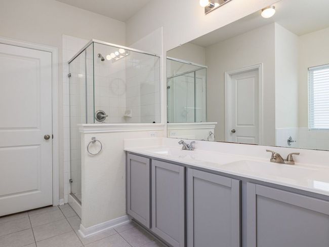 Primary ensuite with a shower stall, tile patterned floors, and double vanity | Image 13