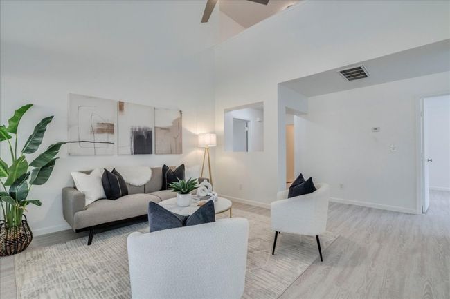 Living room with light wood-type flooring, baseboards, and a ceiling fan | Image 15