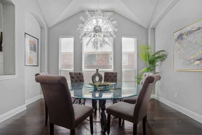 Dining space featuring healthy amount of natural light, hardwood / wood-style floors, vaulted ceiling, and a chandelier | Image 16