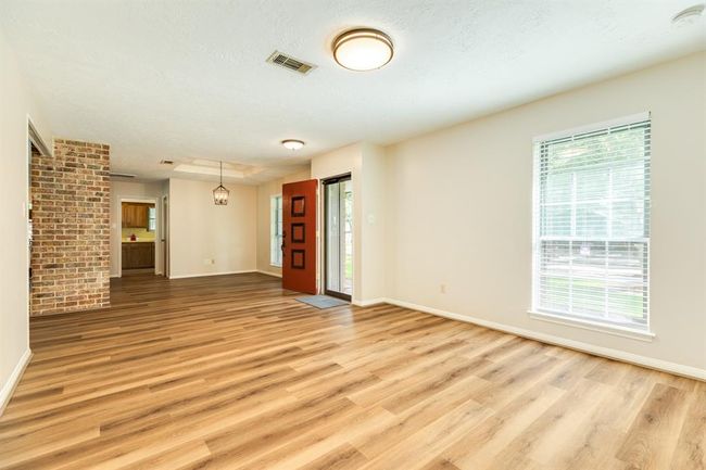 At the front of the home sits the formal living & dining room -- plenty of space to entertain family & friends. LVP throughout the living spaces of the home. Kitchen is at the back of the photo. | Image 4
