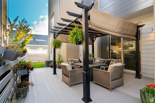 View of patio featuring a custom pergola, an outdoor hangout area, and outdoor dining space | Image 12
