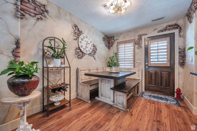 Dining space featuring a textured ceiling, visible vents, and wood finished floors | Image 9