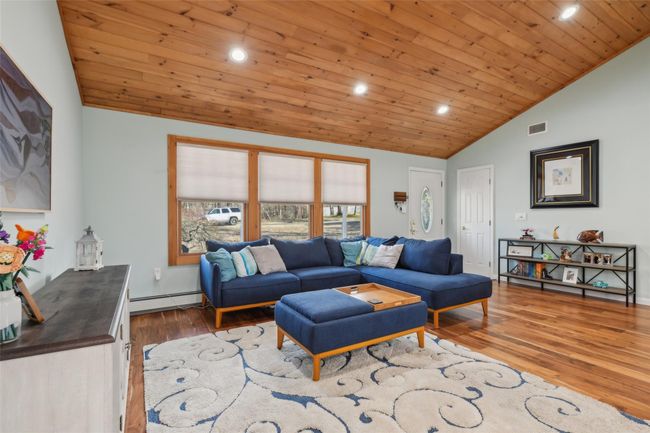 Living room featuring visible vents, a baseboard heating unit, wood ceiling, vaulted ceiling, and wood finished floors | Image 6