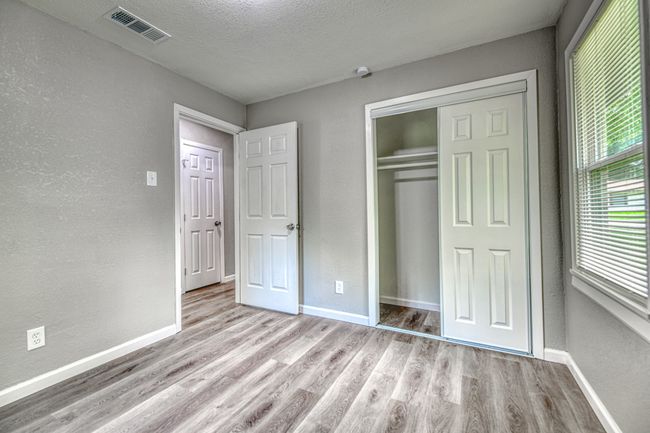 Unfurnished bedroom featuring wood finished floors, a closet, a textured wall, and a textured ceiling | Image 12