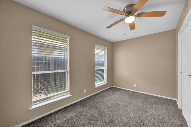 Carpeted empty room with a ceiling fan and baseboards | Image 14
