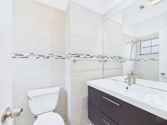 Bathroom with tile walls, vanity, and a tile shower | Image 24