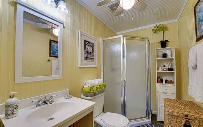 Bathroom with a stall shower, vanity, ceiling fan, toilet, and visible vents | Image 18