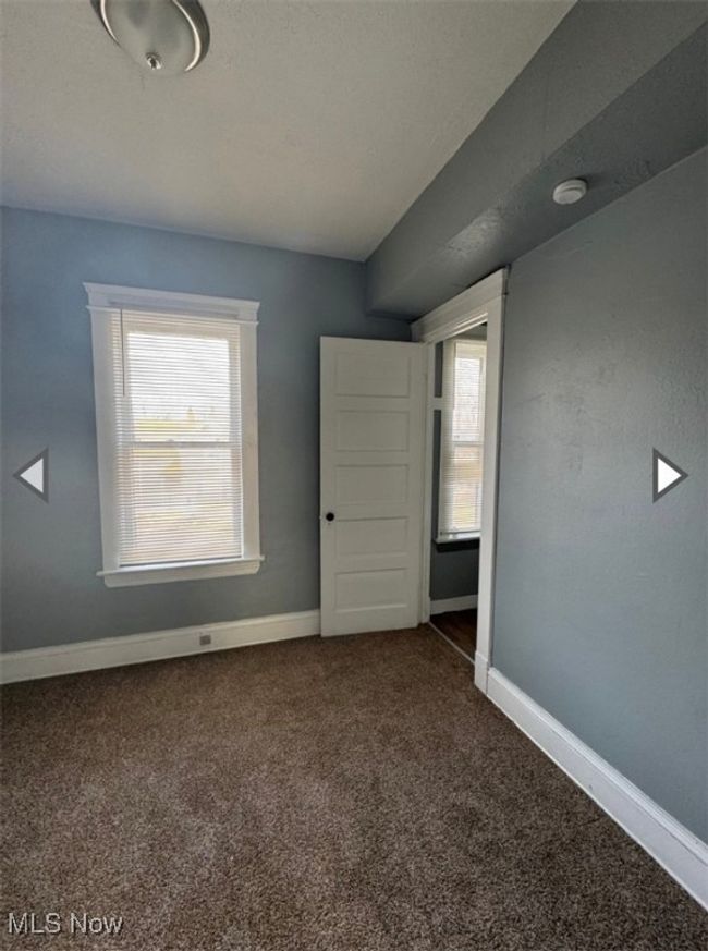 Empty room featuring dark carpet and plenty of natural light | Image 7