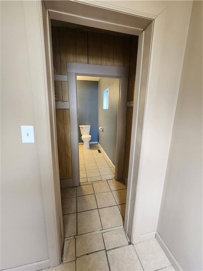Bathroom with tile patterned floors, toilet, and baseboards | Image 18