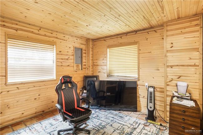 Office space with wooden walls, wood ceiling, and tile patterned floors | Image 17