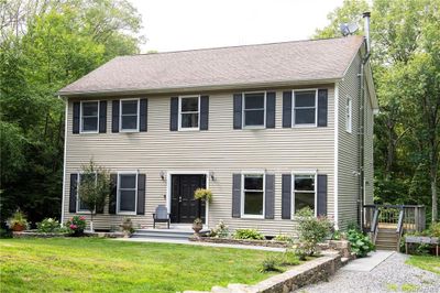 Colonial home featuring a wooden deck and a front lawn | Image 1