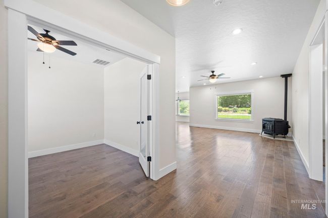 Empty room featuring a ceiling fan, a wood stove, wood finished floors, and recessed lighting | Image 21