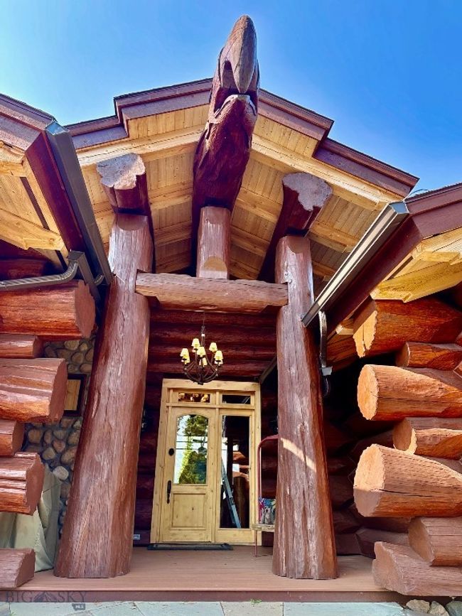 Grand entryway to home with massive log accents and ski lift chair. | Image 91