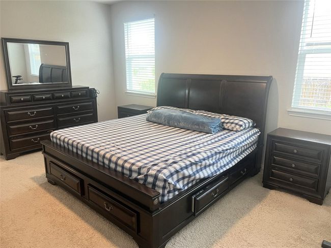 Bedroom featuring light colored carpet and multiple windows | Image 13
