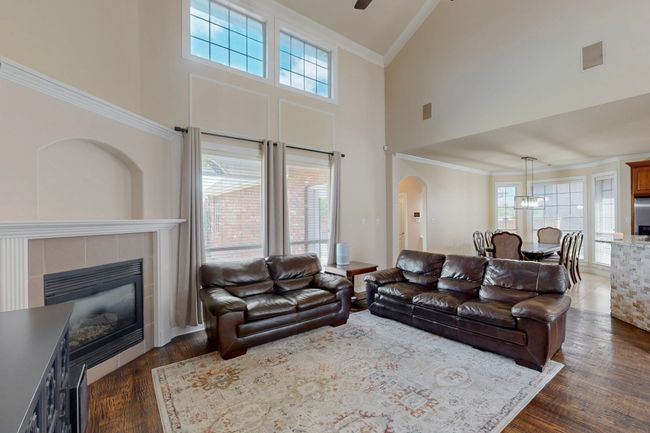 Living area with arched walkways, plenty of natural light, high vaulted ceiling, and ornamental molding | Image 5