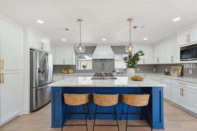 Designed to impress, the chef’s kitchen boasts a spacious accent island and an open layout perfect for cooking, gathering, and entertaining. | Image 10