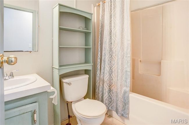 Full bathroom with shower / tub combo with curtain, vanity, patterned flooring | Image 28
