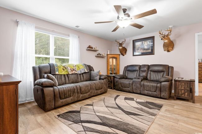 Living room with ceiling fan and light wood-type flooring | Image 12