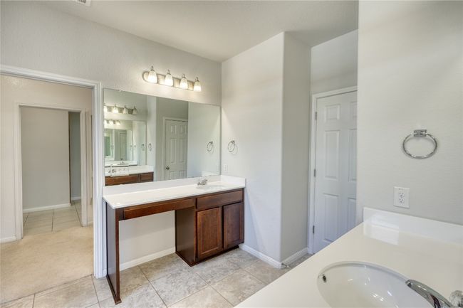 Bathroom with a sink, baseboards, two vanities, and tile patterned flooring | Image 20