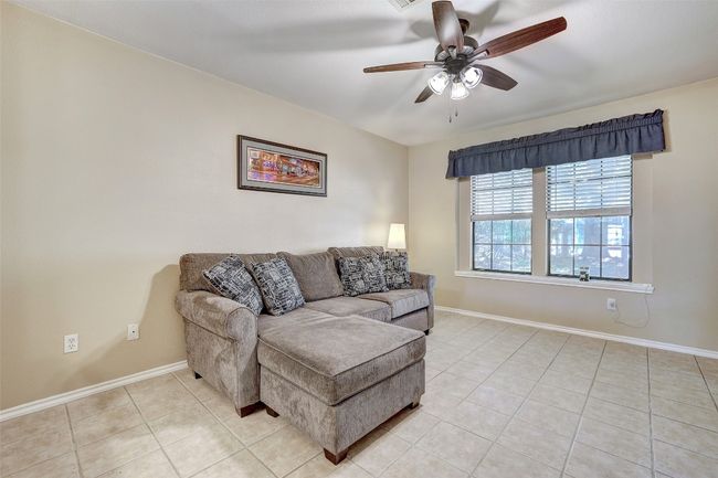 Living room featuring a ceiling fan, light tile patterned floors, and baseboards | Image 12