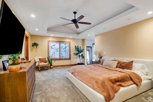 Bedroom with a tray ceiling, vaulted ceiling, baseboards, light colored carpet, and recessed lighting | Image 15