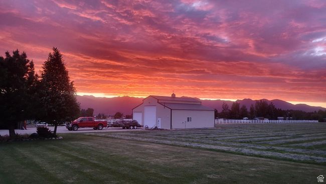 Outdoor structure at dusk featuring an outbuilding, a mountain view, and fence | Image 44