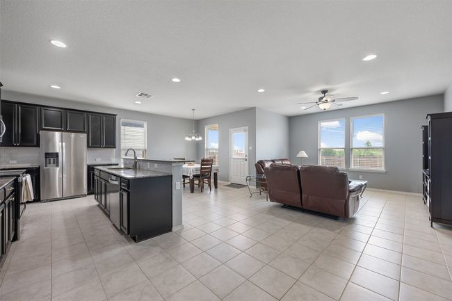 Kitchen featuring plenty of natural light, dark cabinets, stainless steel appliances, and a sink | Image 11